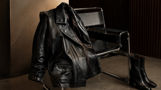 Oversized black leather jacket draped over a modern chair