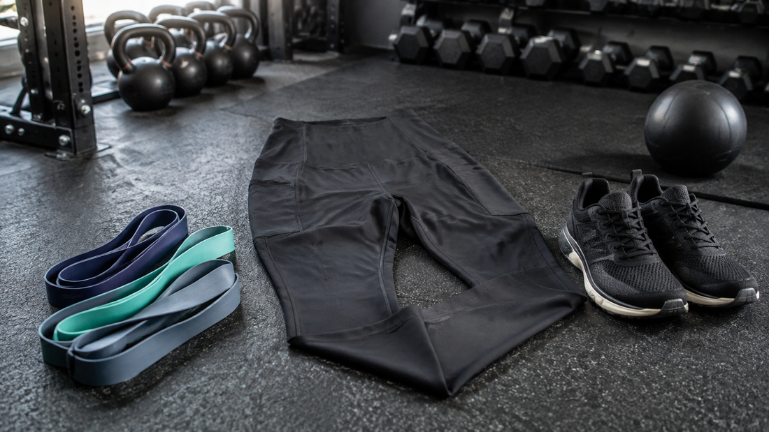 Performance workout leggings arranged with gym accessories