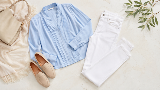 Women's white jeans styled with a pale blue blouse and loafers