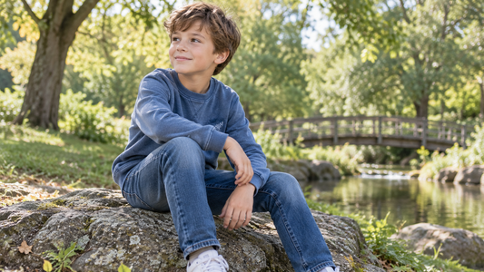 Boy wearing comfortable blue jeans in a leafy park