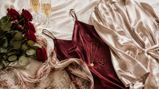 Rose and champagne satin camisole and robe arranged with minimalist jewelry