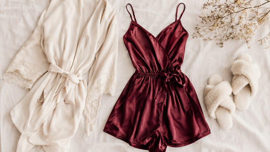 Burgundy silk lounge romper cream robe and slippers on pale linen
